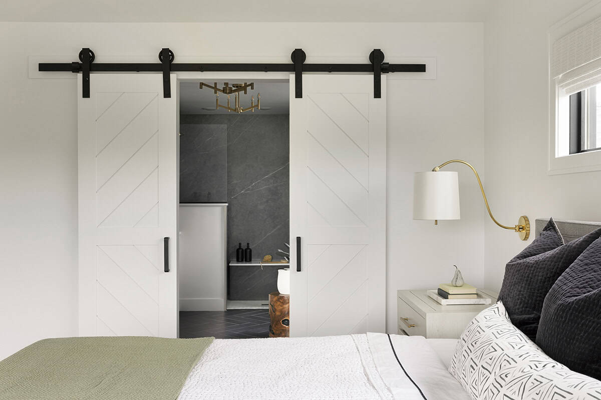 Bedroom view through sliding barn doors into ensuite bathroom