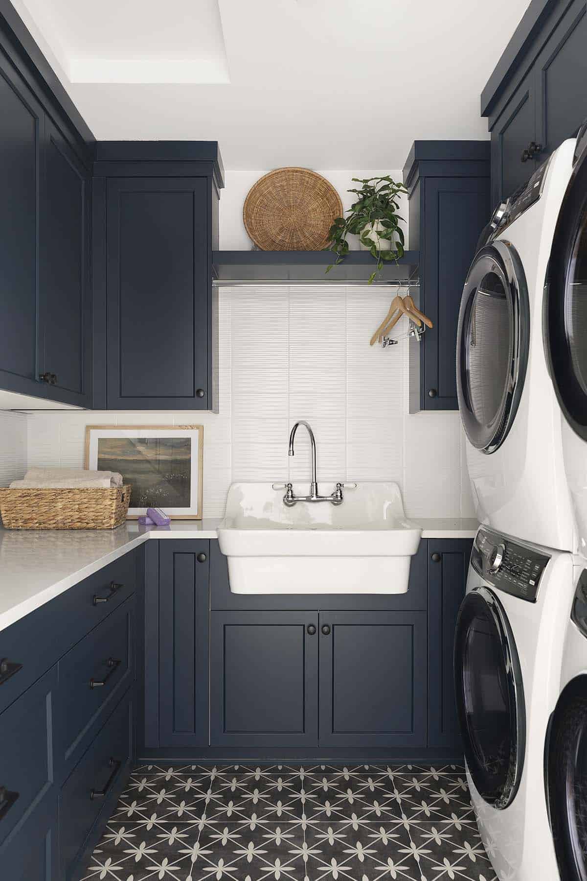 Laundry room with navy cabinetry and farmhouse-style sink