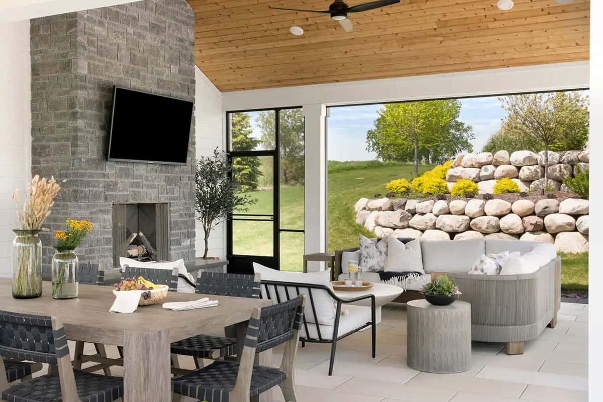 Covered patio with stone fireplace and wall-mounted TV