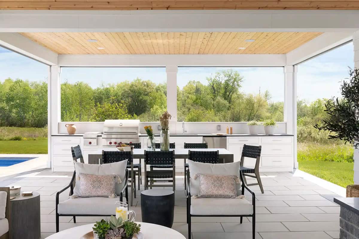 Covered outdoor living space with dining table and screened walls