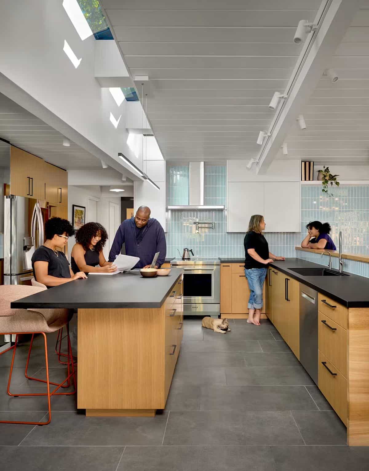 Family gathered around kitchen island with blue tile backsplash