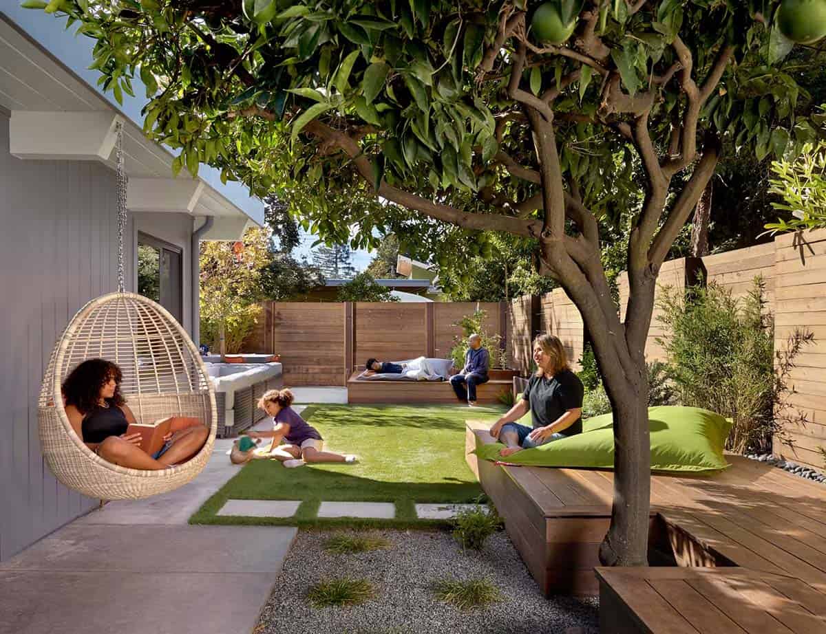 Family relaxing in backyard with hanging chair and citrus tree