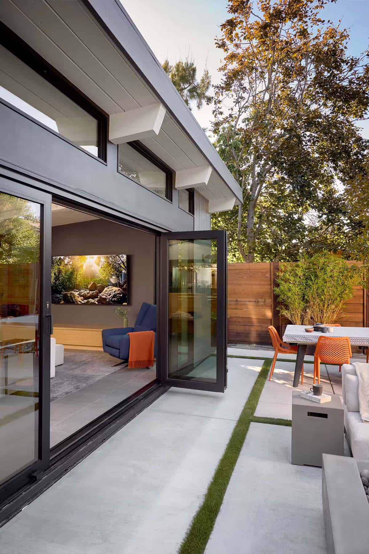 Folding glass doors opening living room to backyard patio