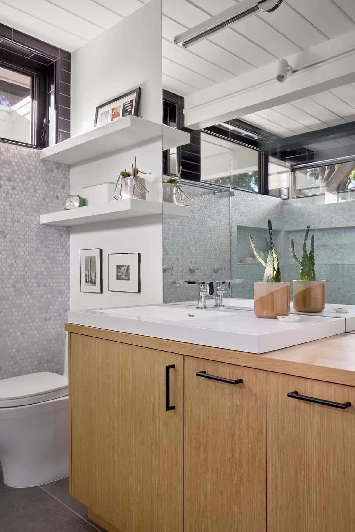 White vanity countertop with oak cabinets and potted succulents