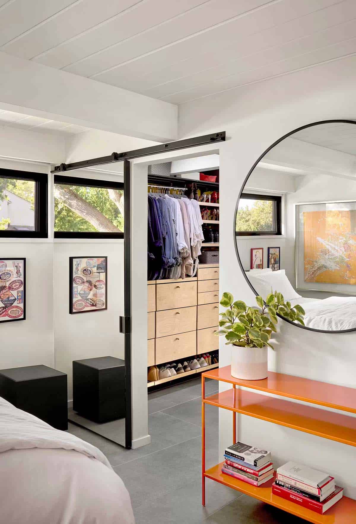 Organized walk in closet with sliding barn door and mirror