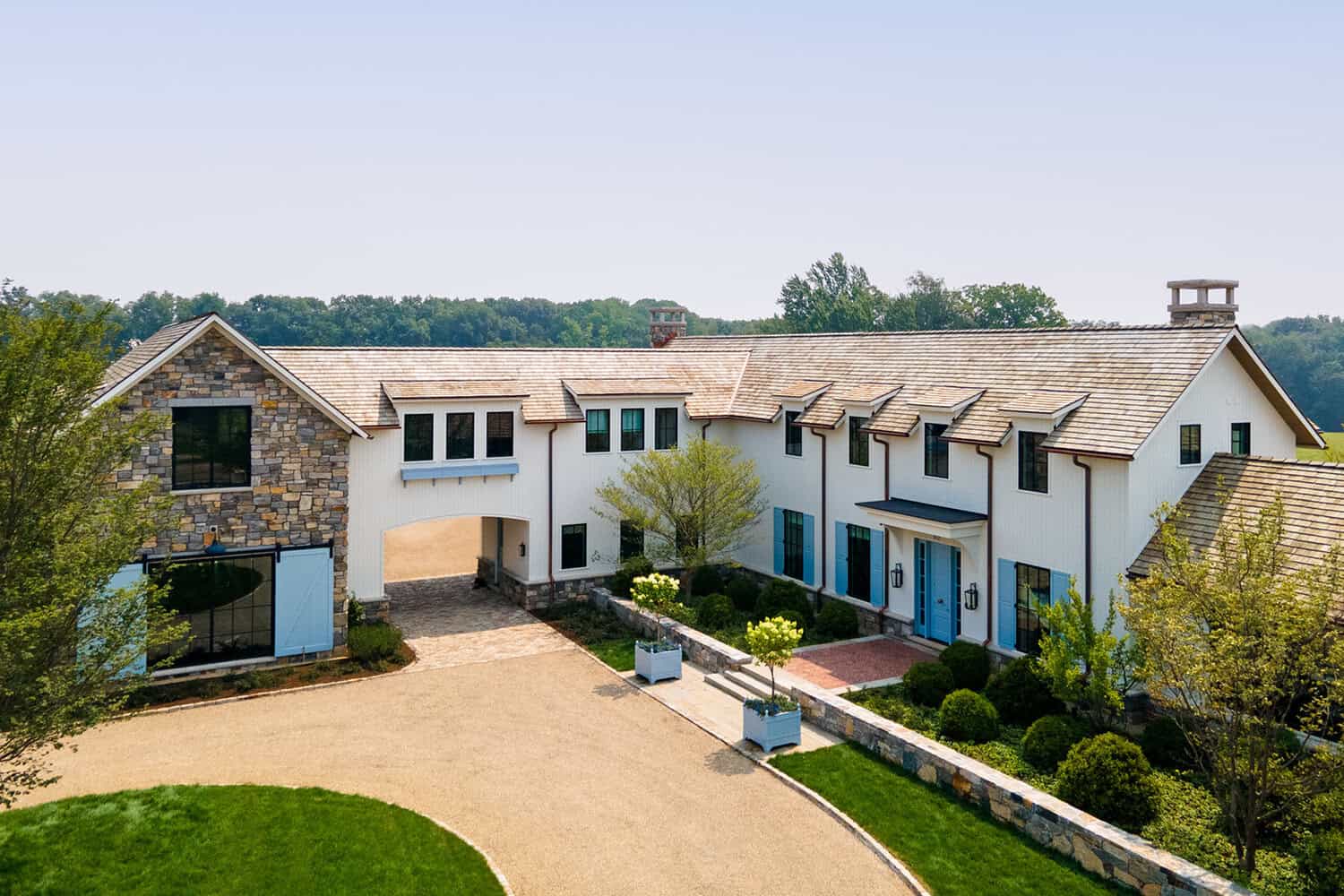 Aerial view of English country farmhouse with stone porte-cochère entry