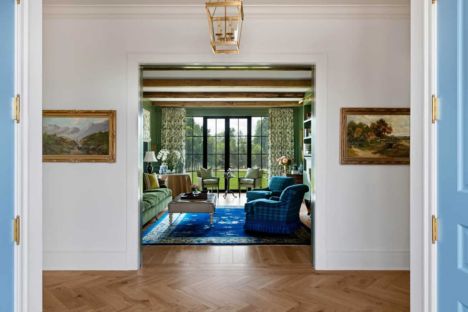 View into green library with gallery wall and French doors