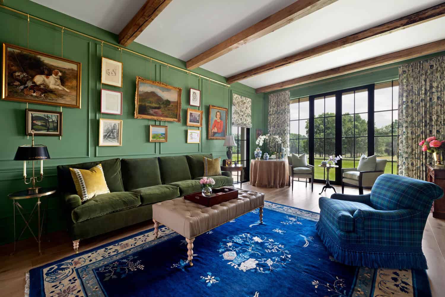 Green paneled sitting room with velvet sofa and plaid armchairs