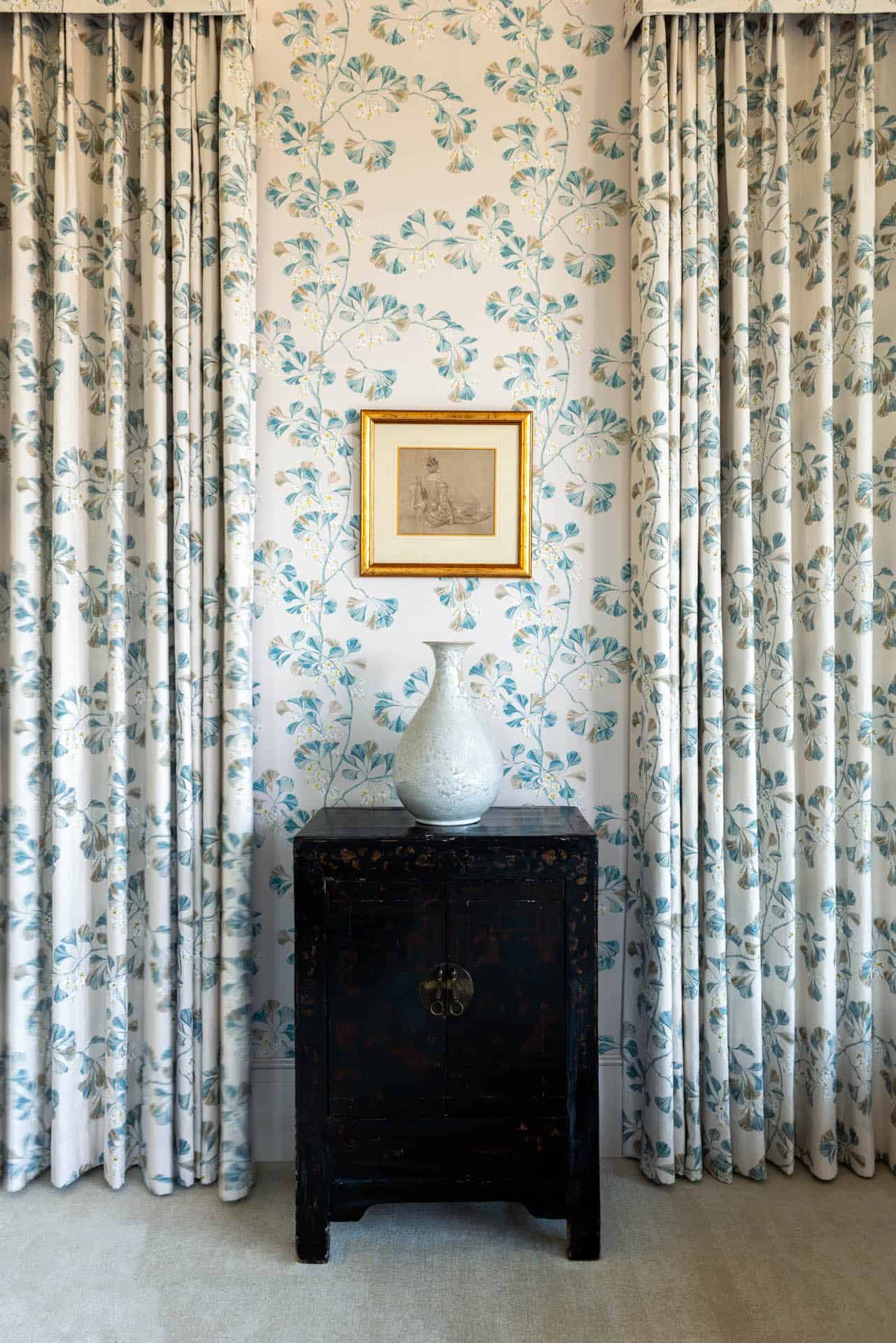 Floral wallpaper vignette with gilt frame and antique chest
