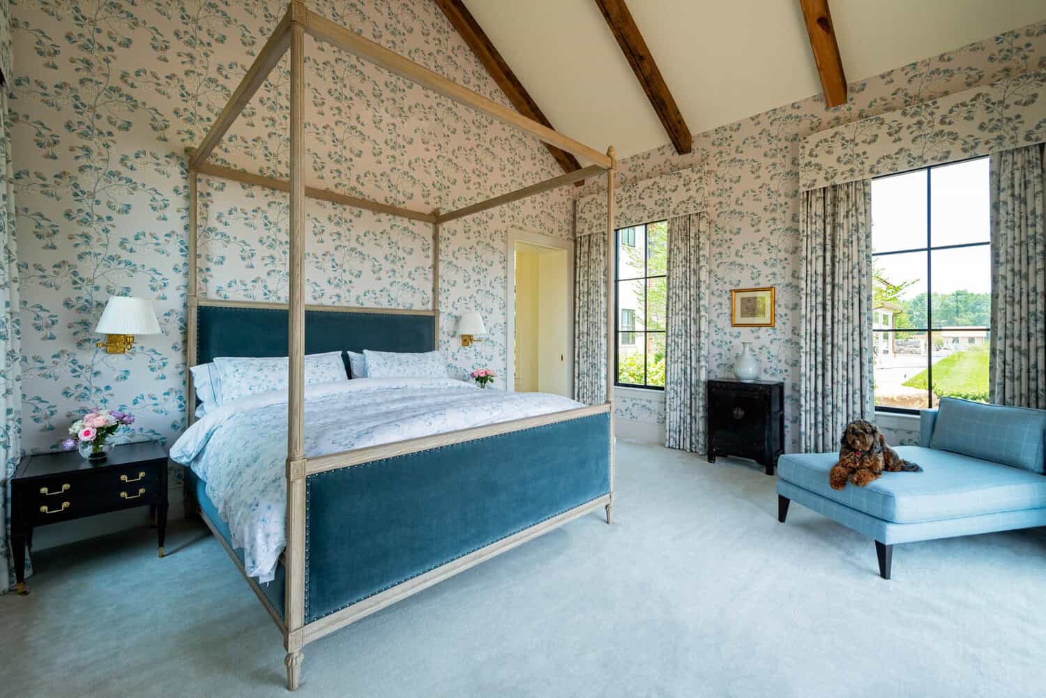 Primary bedroom with canopy bed and floral wallpaper