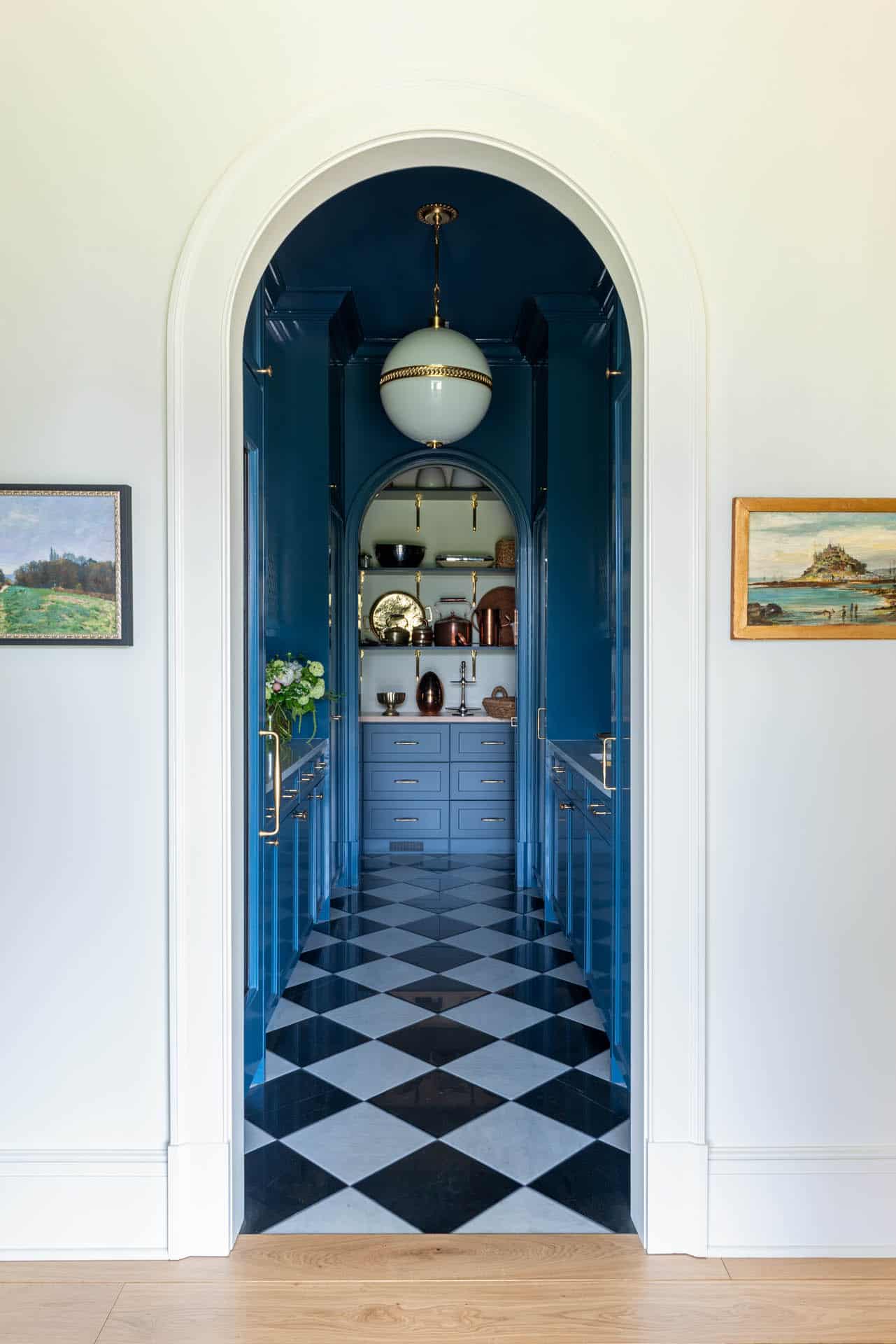 Arched doorway into blue lacquered butler's pantry