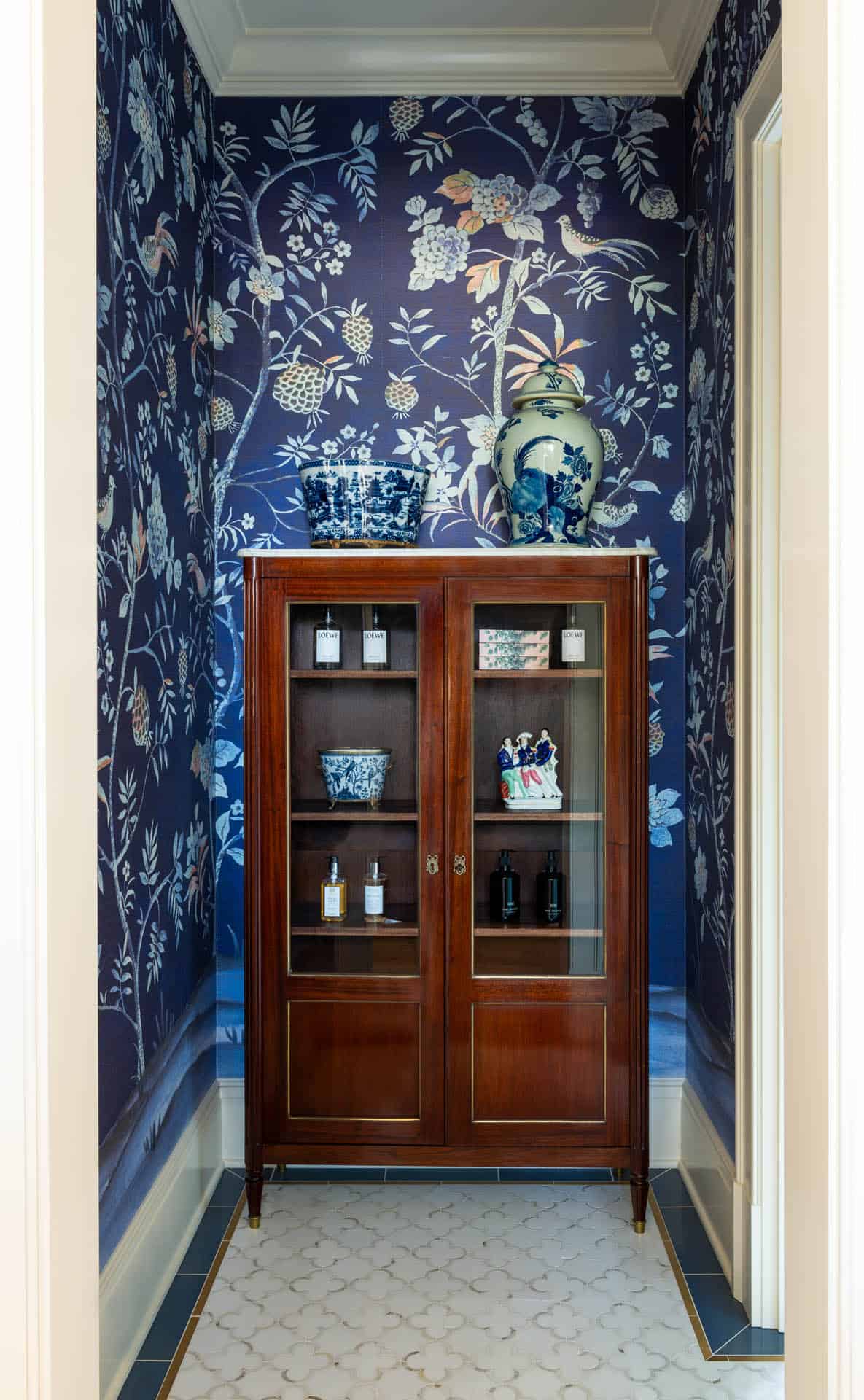 Antique cabinet display in navy chinoiserie wallpaper nook