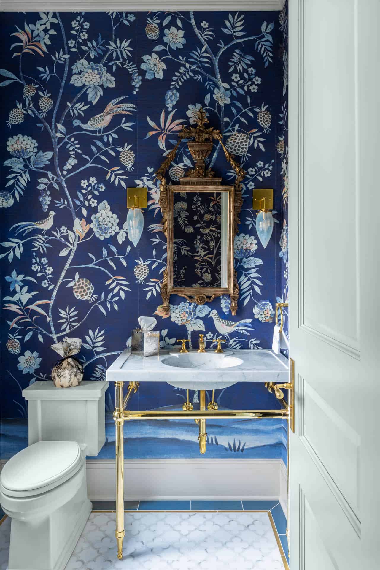 Powder room with navy floral wallpaper and gilt mirror