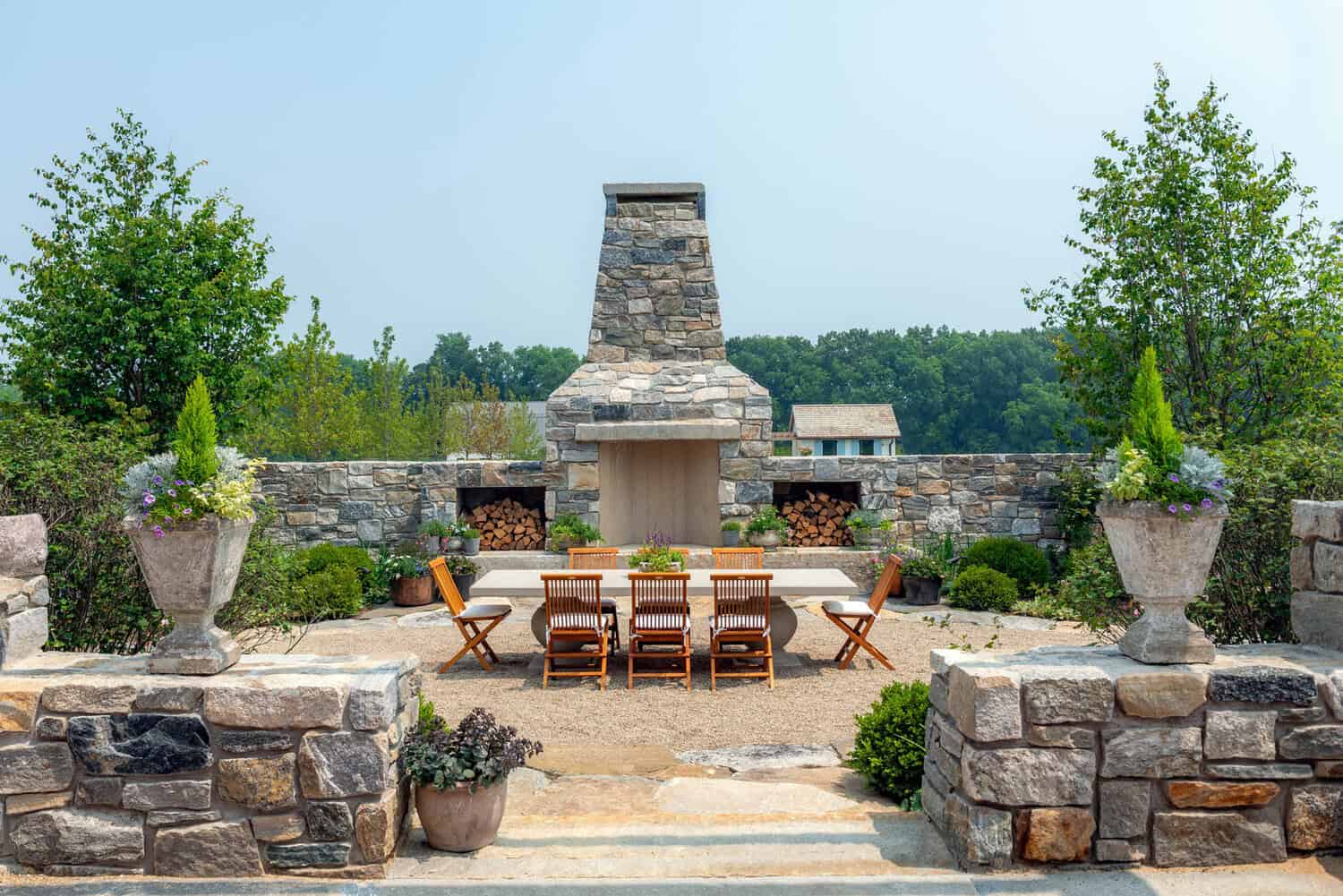 Outdoor stone fireplace with dining table and terrace walls