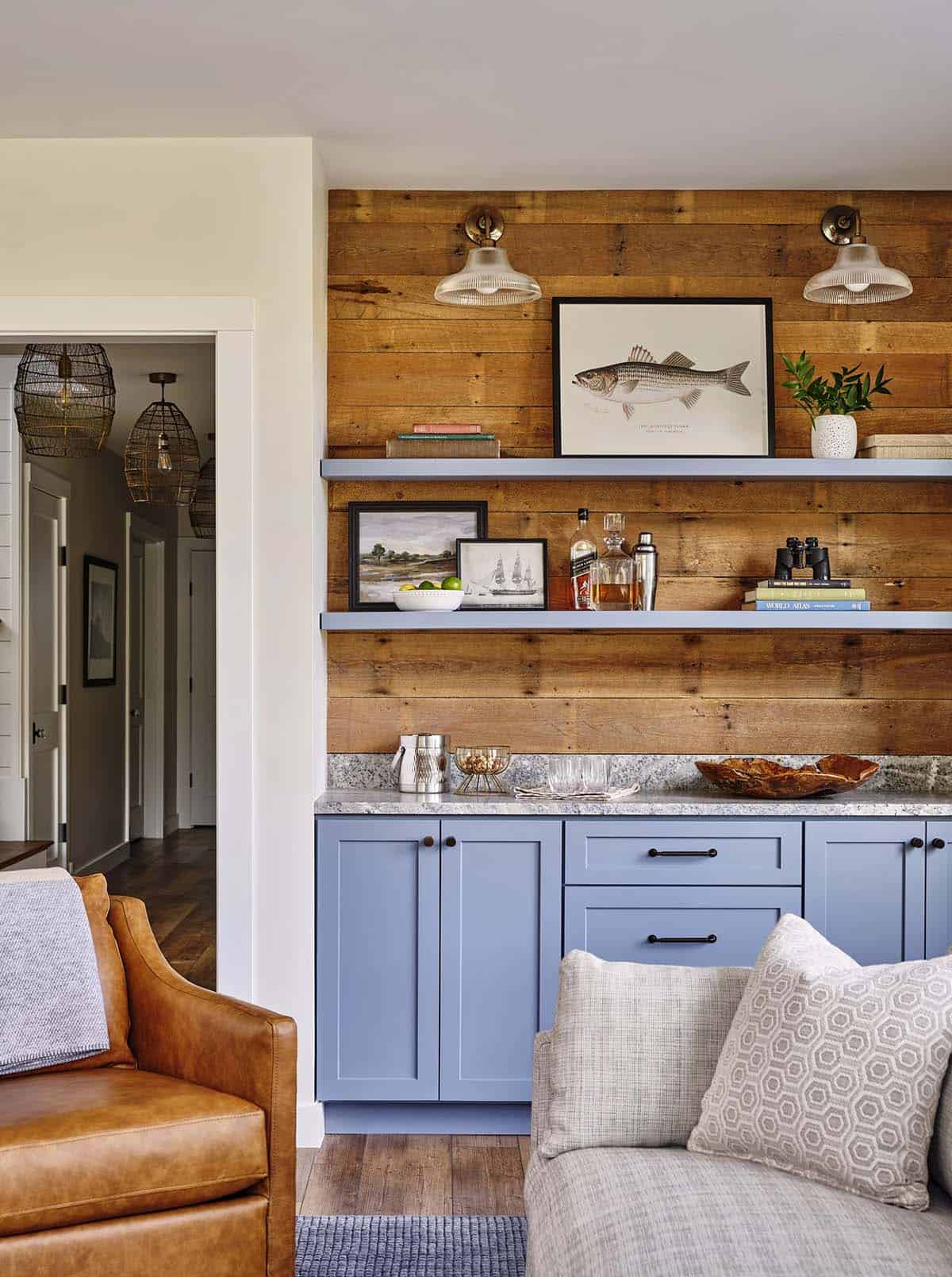 Wet bar area with reclaimed wood wall, light blue cabinetry, granite counter, and fish artwork