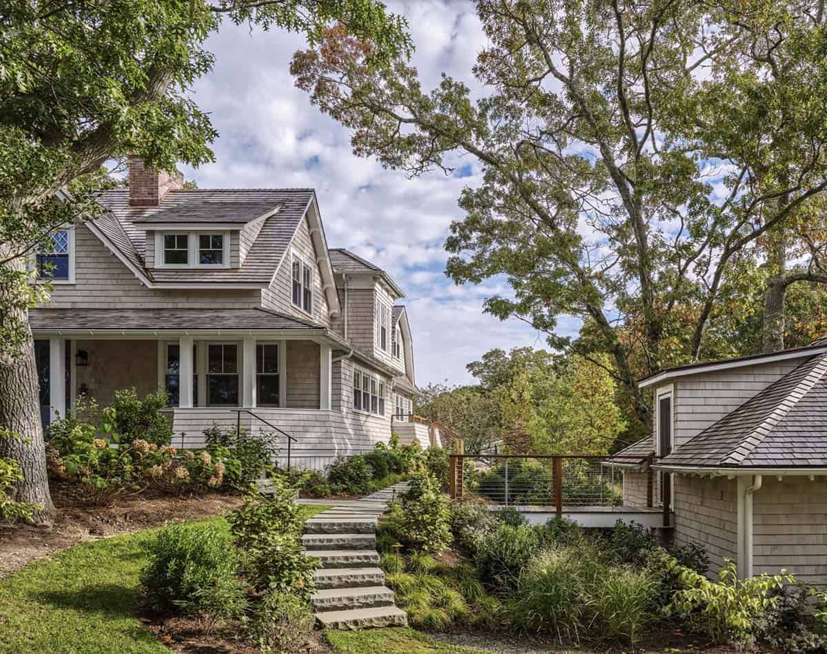 Exterior side view of shingled home with stone garden steps and cable-rail deck