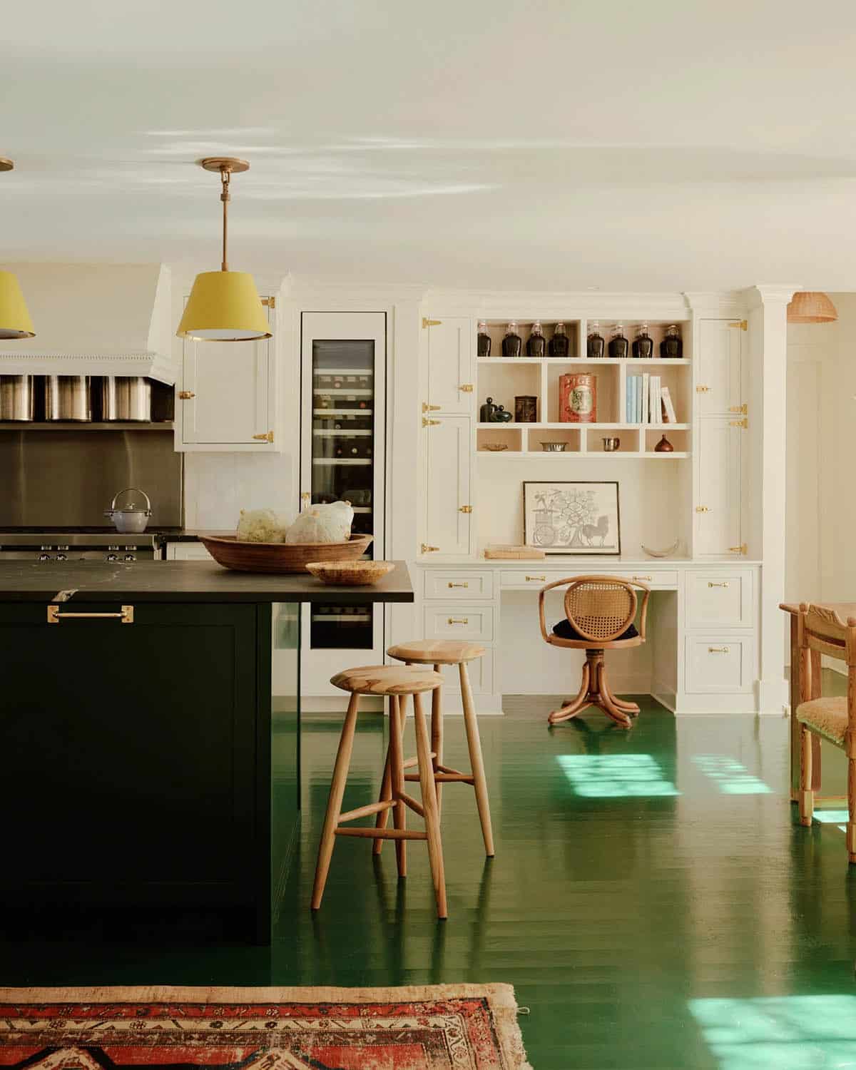Kitchen with dark green island, black soapstone counter, and built-in desk nook