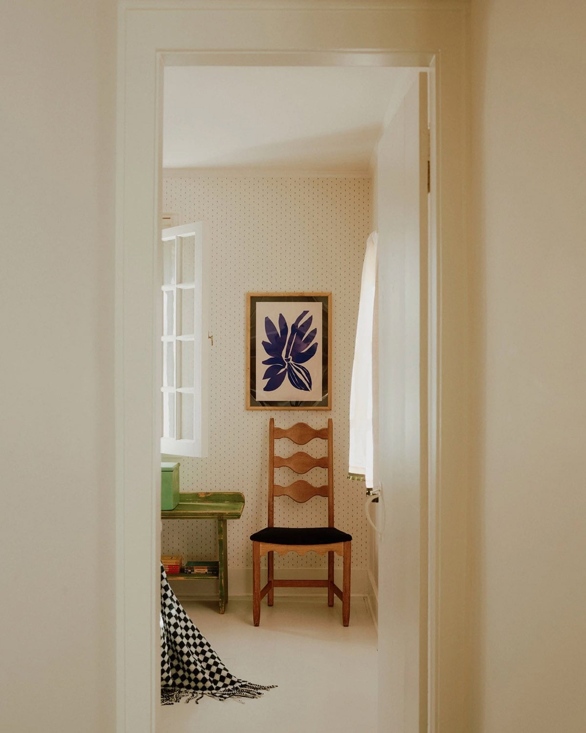 Nook with ladder-back chair, green vintage bench, and blue botanical artwork