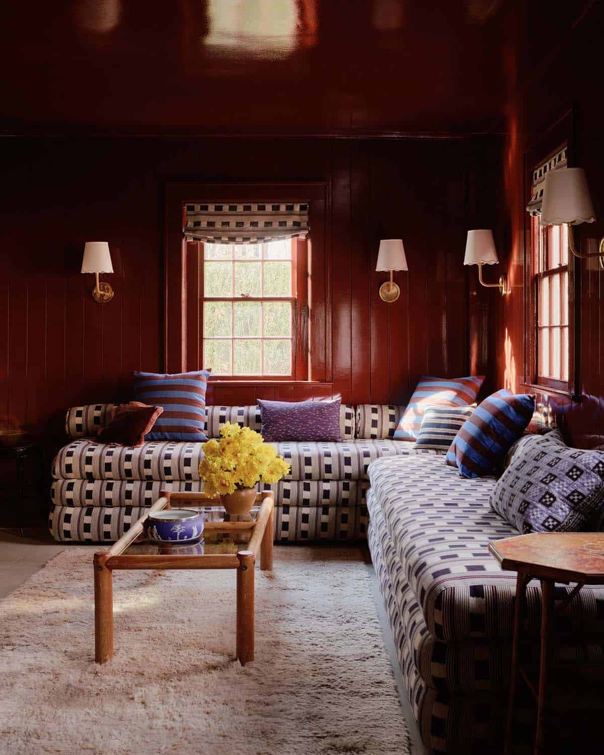 Red lacquered den with striped and patterned pillows