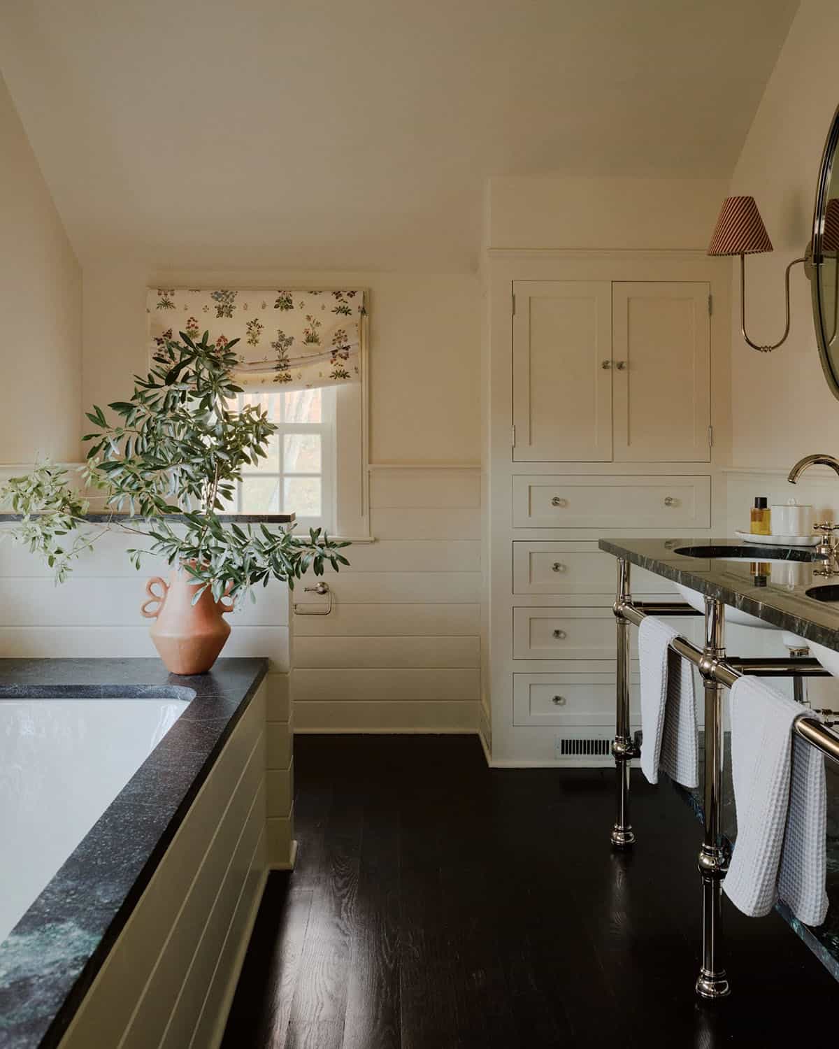 Bathroom with black stone-topped tub, terracotta vase, and nickel towel rail