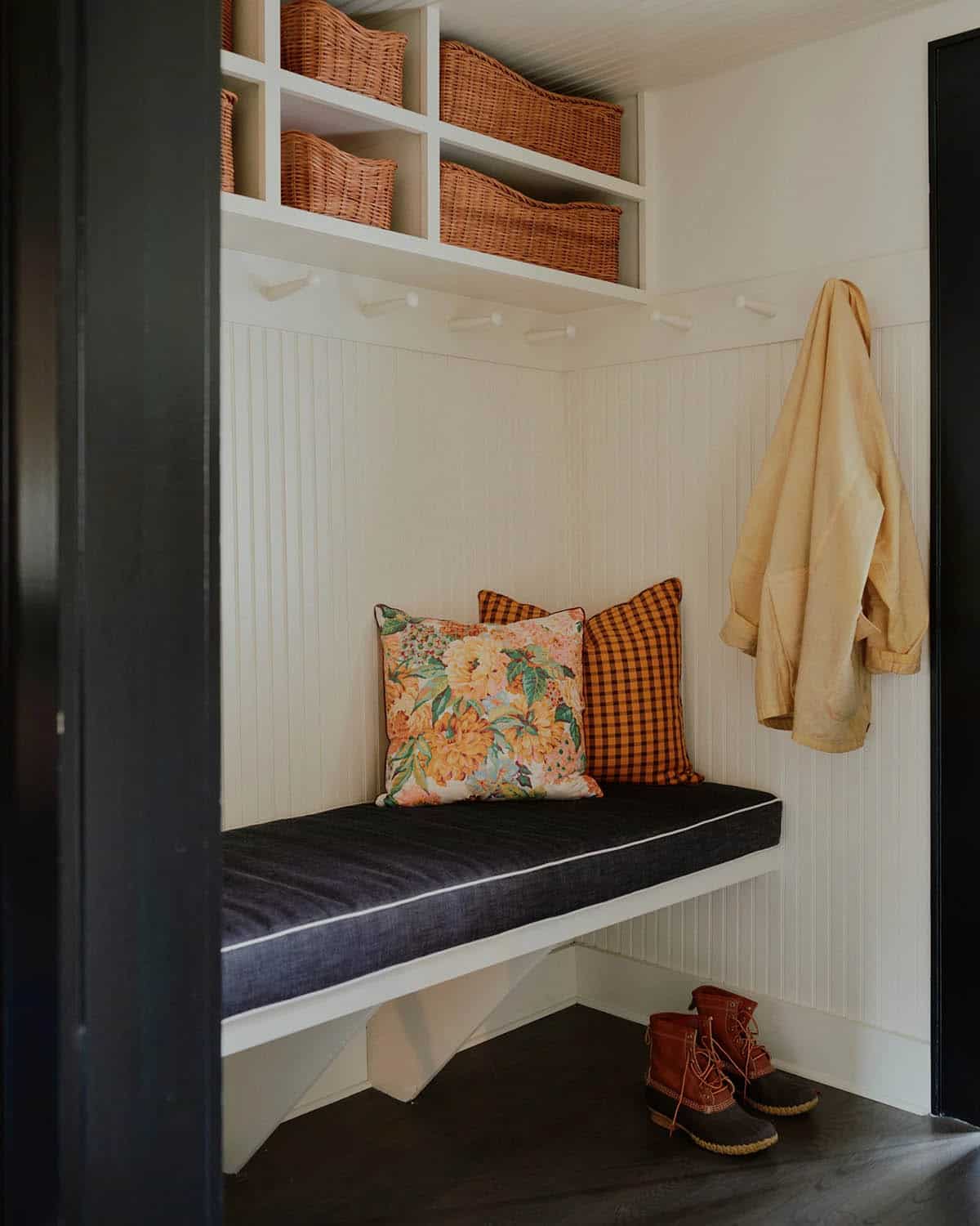 Mudroom nook with wicker storage baskets, denim bench cushion, and Bean boots