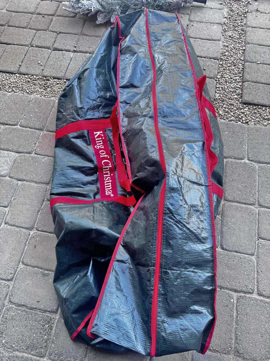 King of Christmas tree storage bag folded closed on pavers