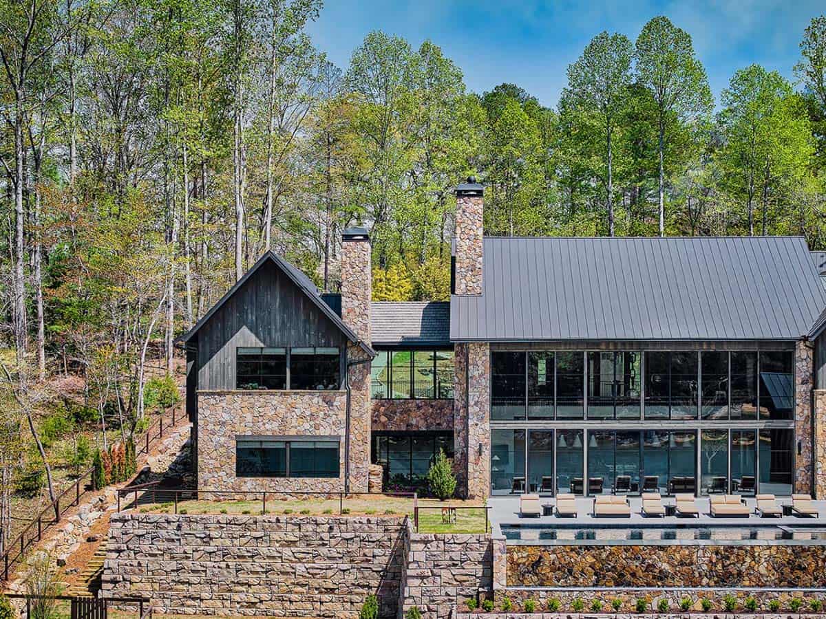 Stone and dark wood lake house exterior with pool terrace views