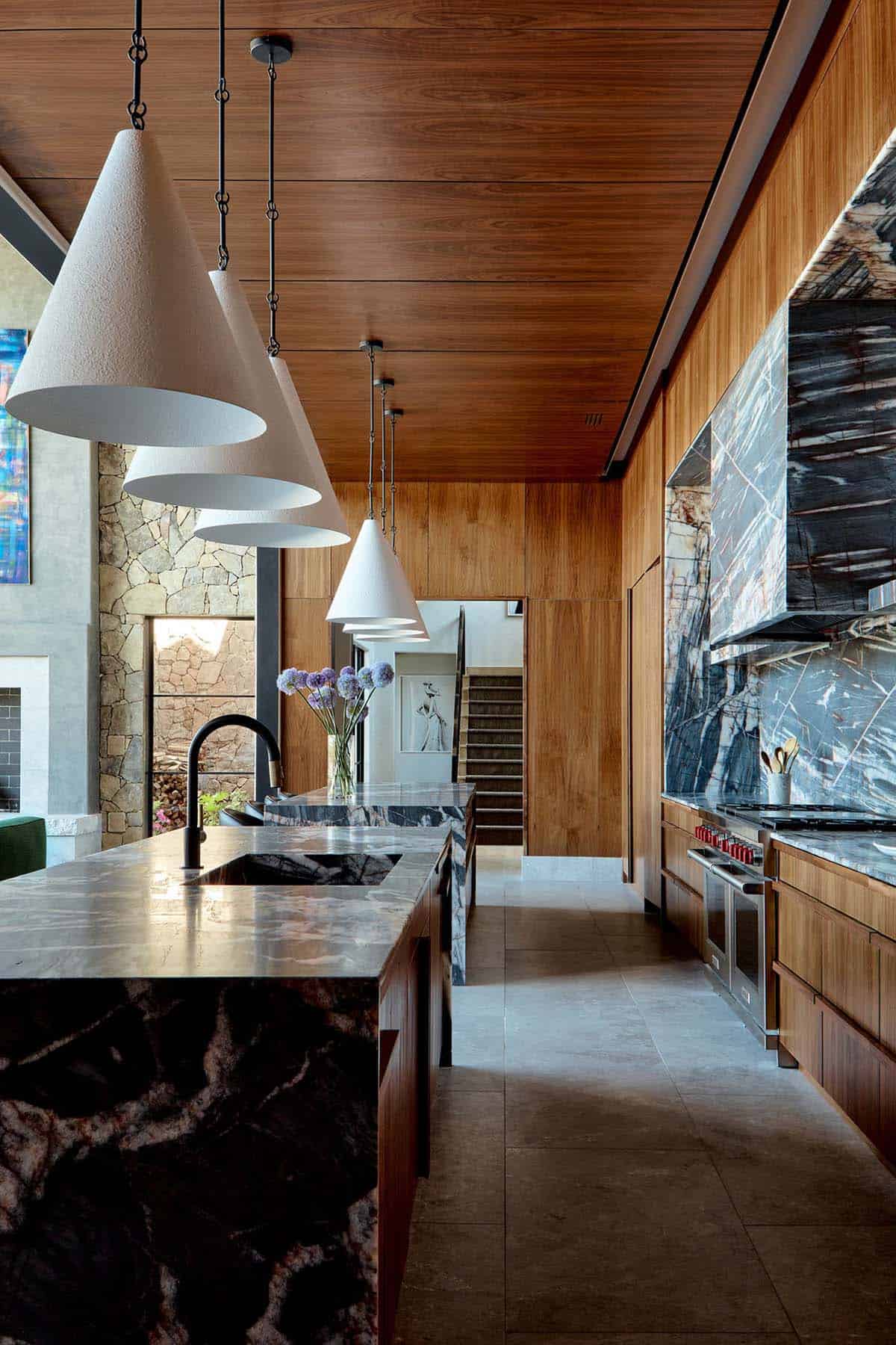 Kitchen island with cone pendant lights and dramatic quartzite backsplash