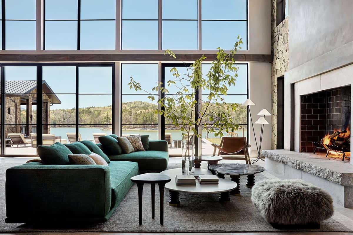 Living room with emerald sofa facing floor to ceiling lake windows