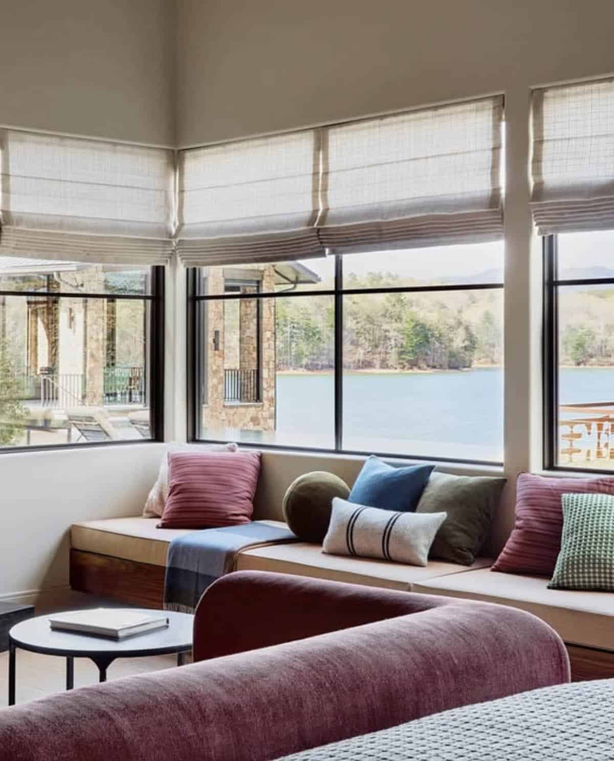 Window seat bench with layered pillows overlooking mountain lake views
