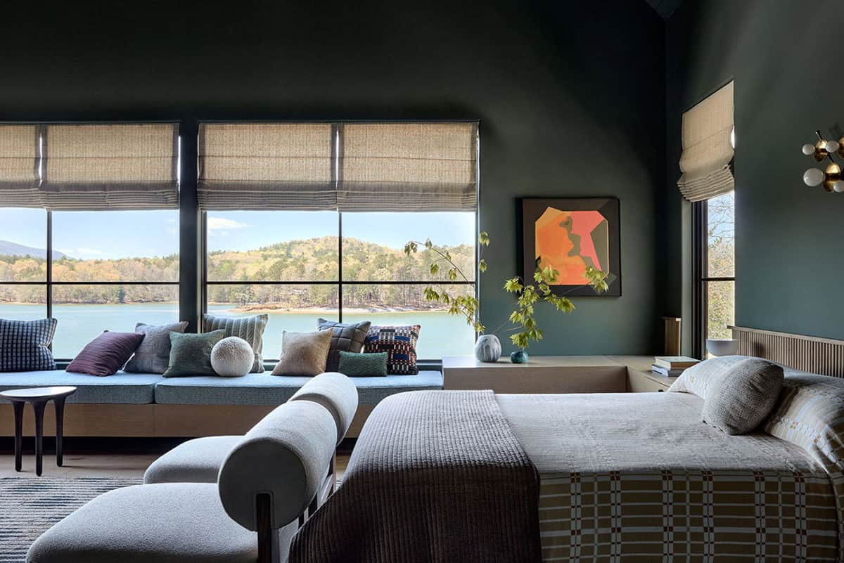 Dark green bedroom with lake view daybed and abstract wall art