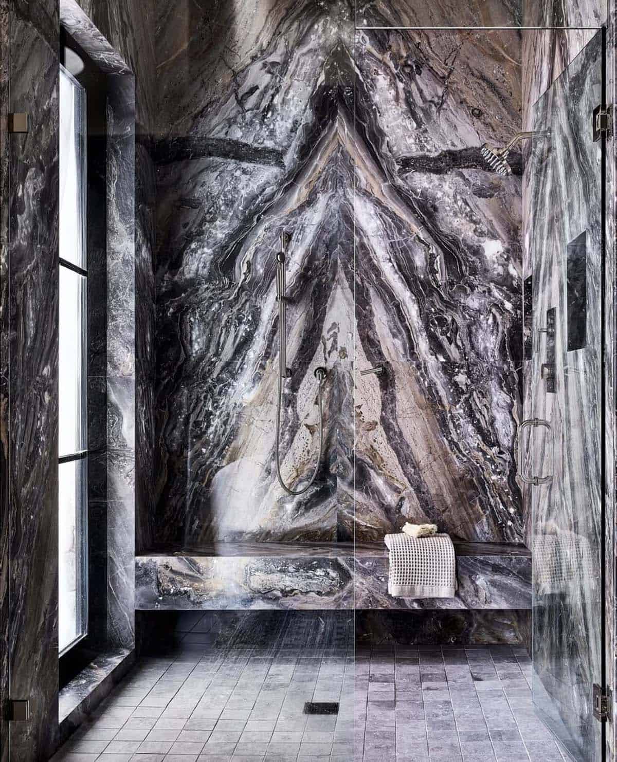 Marble clad shower with dramatic veining and glass enclosure