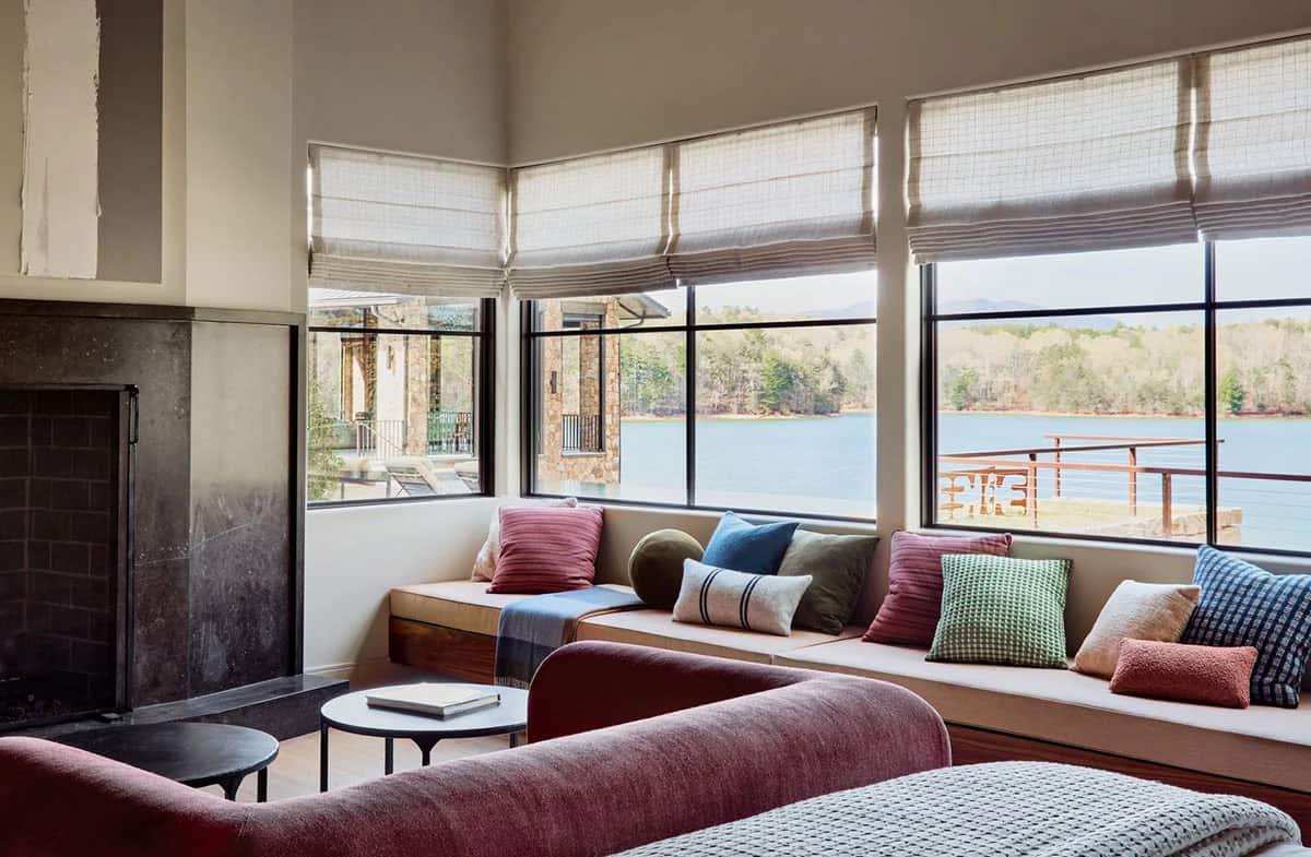 Corner window seat with mixed pillows overlooking lake and mountains