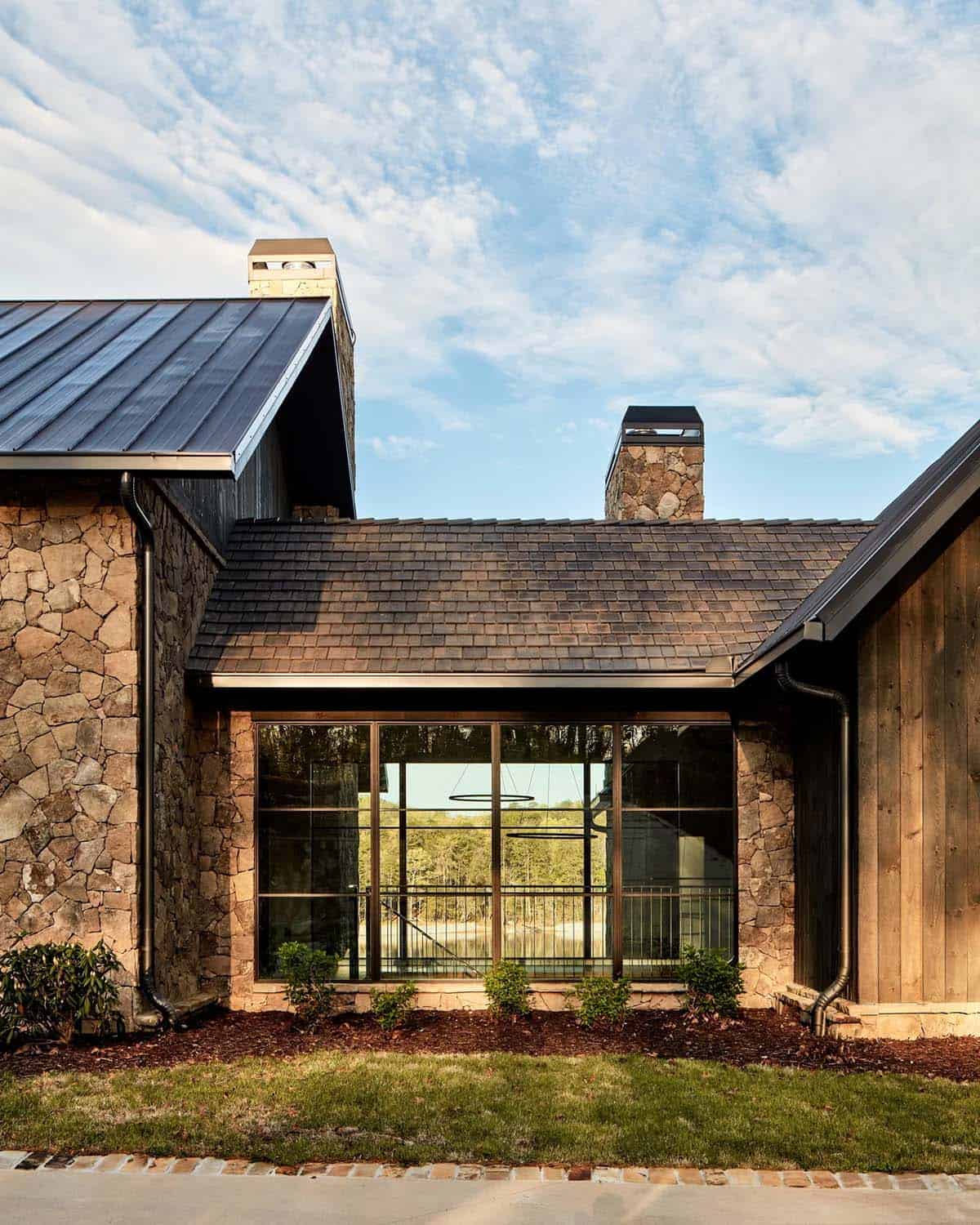 Exterior gable detail with stone chimney and reflective window wall