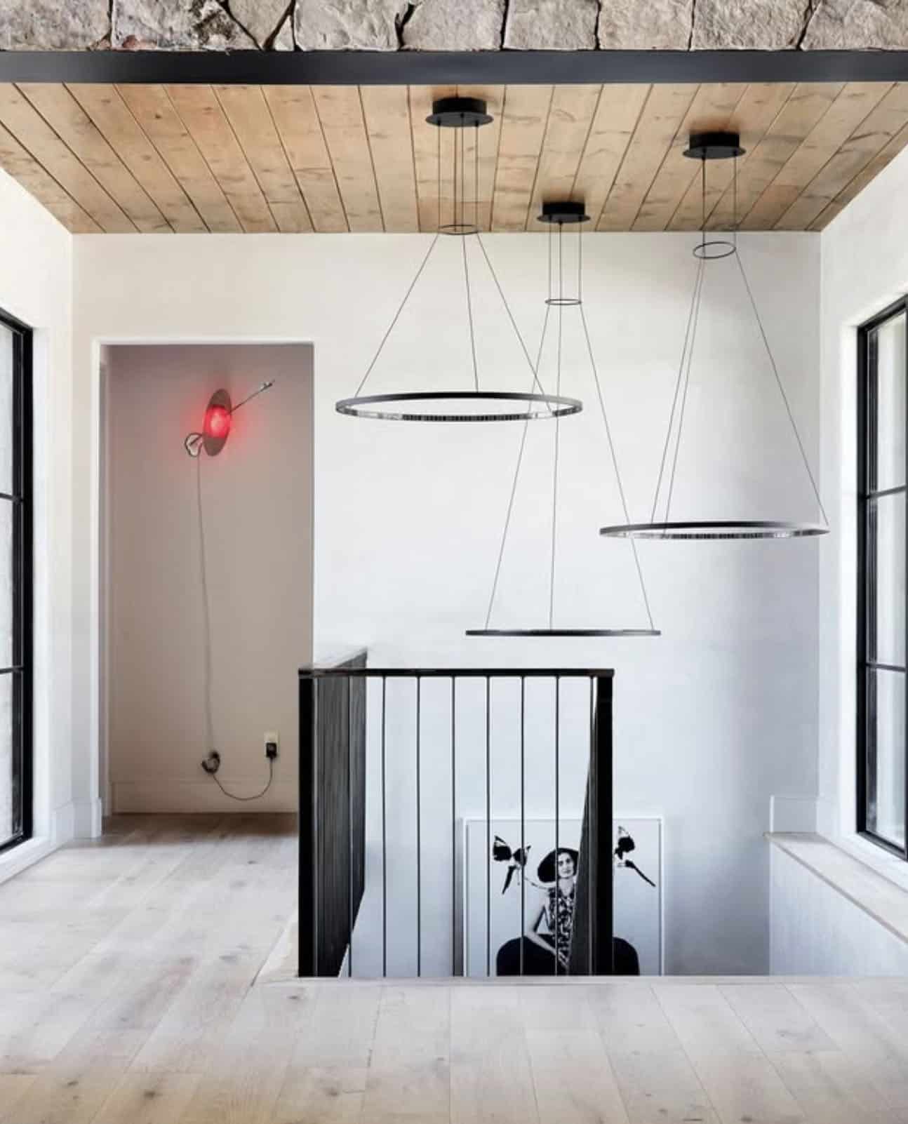 Upstairs landing with circular pendant lights and red wall sconce