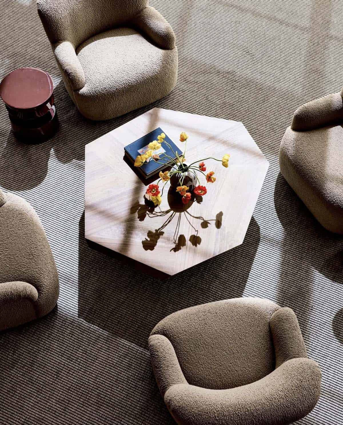 Overhead view of hexagonal coffee table styled with poppies and books