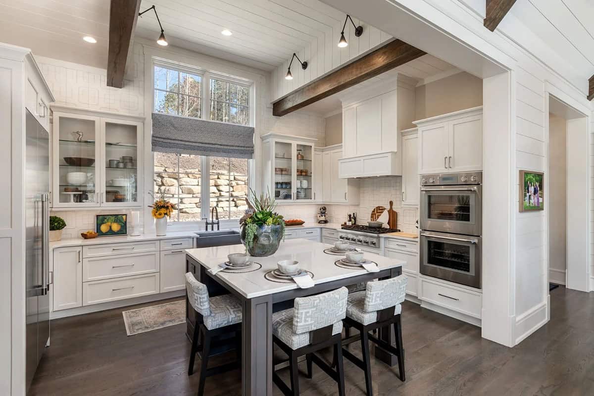 White kitchen with center island, glass-front cabinets, and double wall ovens