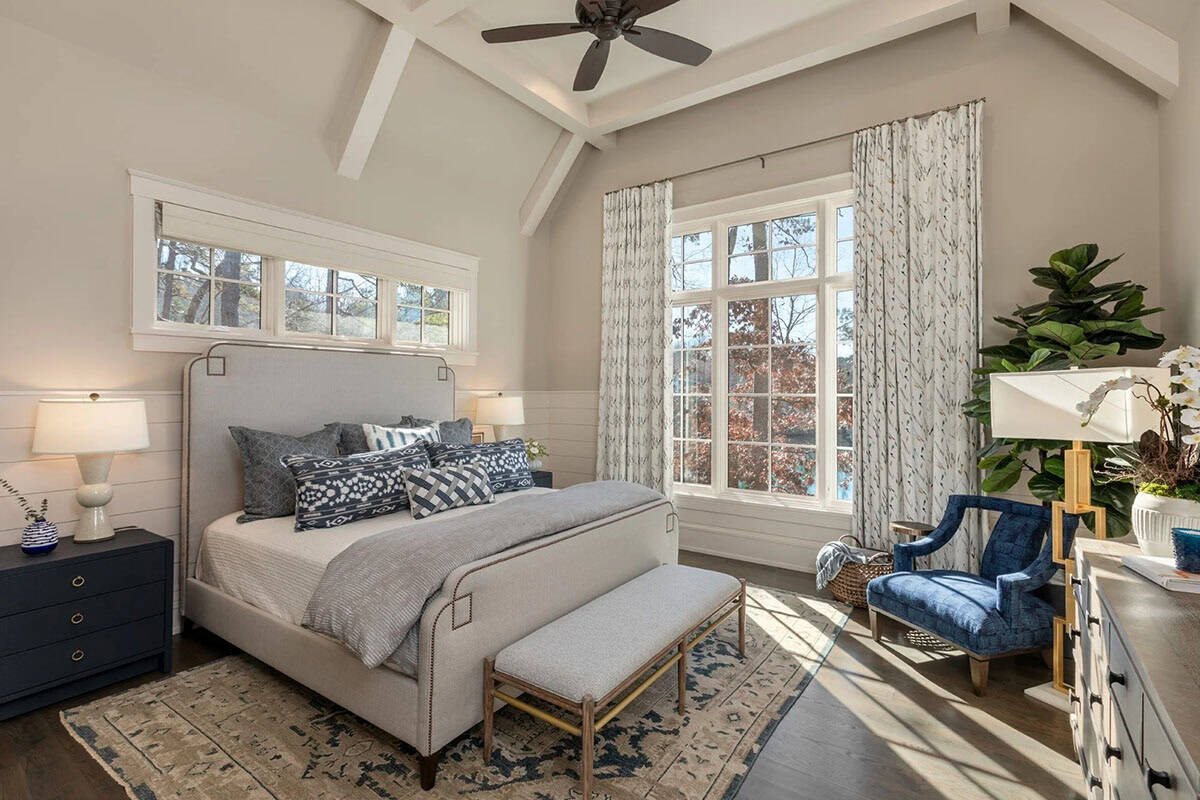 Bedroom with upholstered bed, patterned pillows, and vaulted beamed ceiling