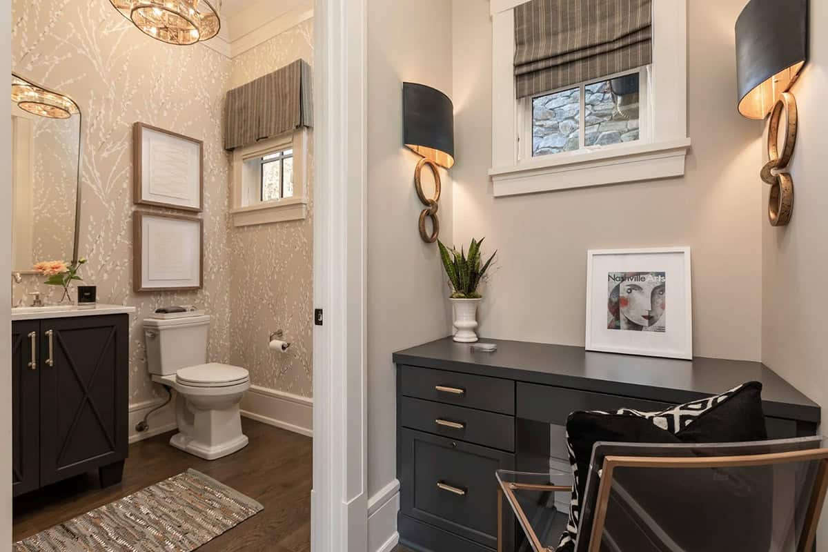 Powder room with botanical wallpaper next to built-in desk nook with sconces