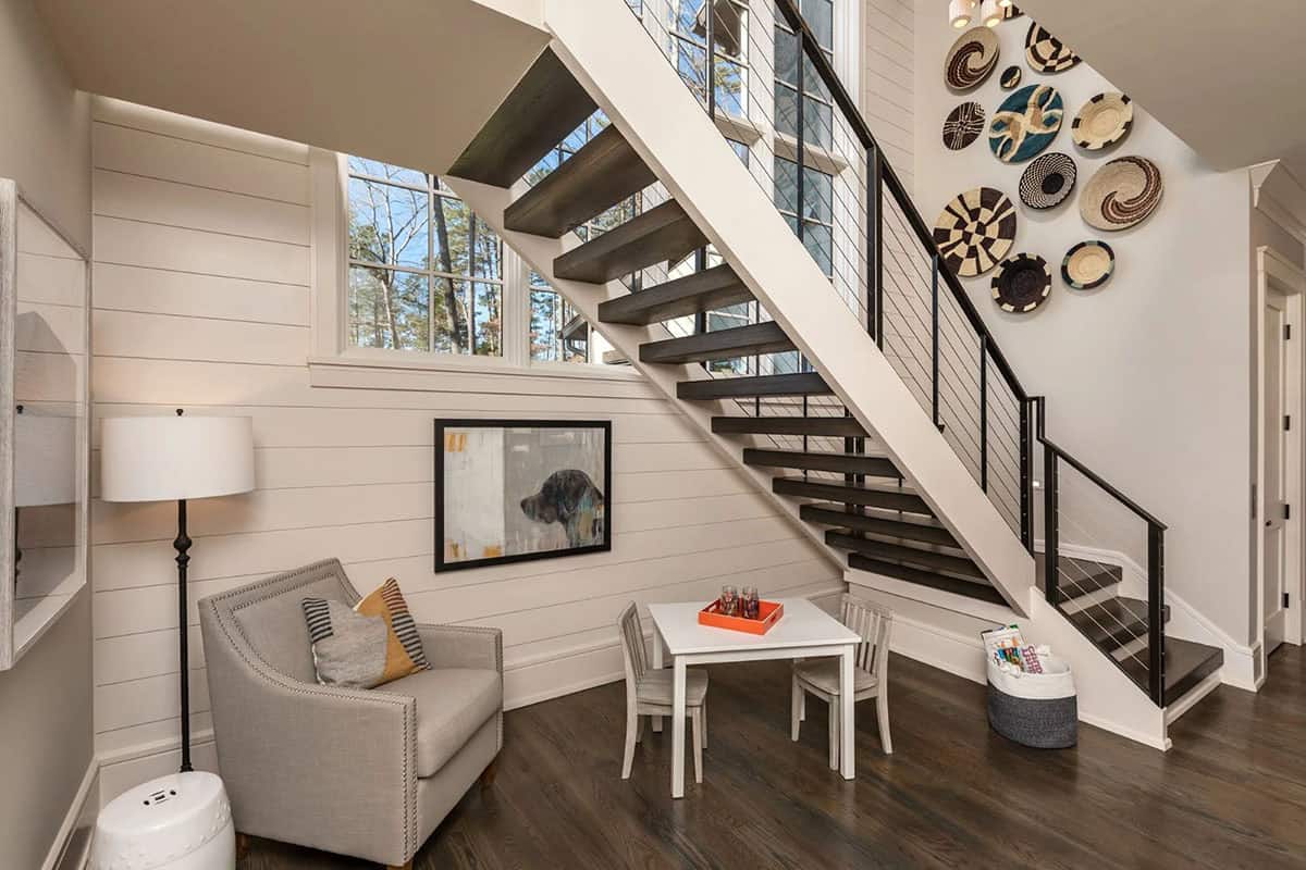 Staircase landing with kids' table, armchair, and woven basket wall display