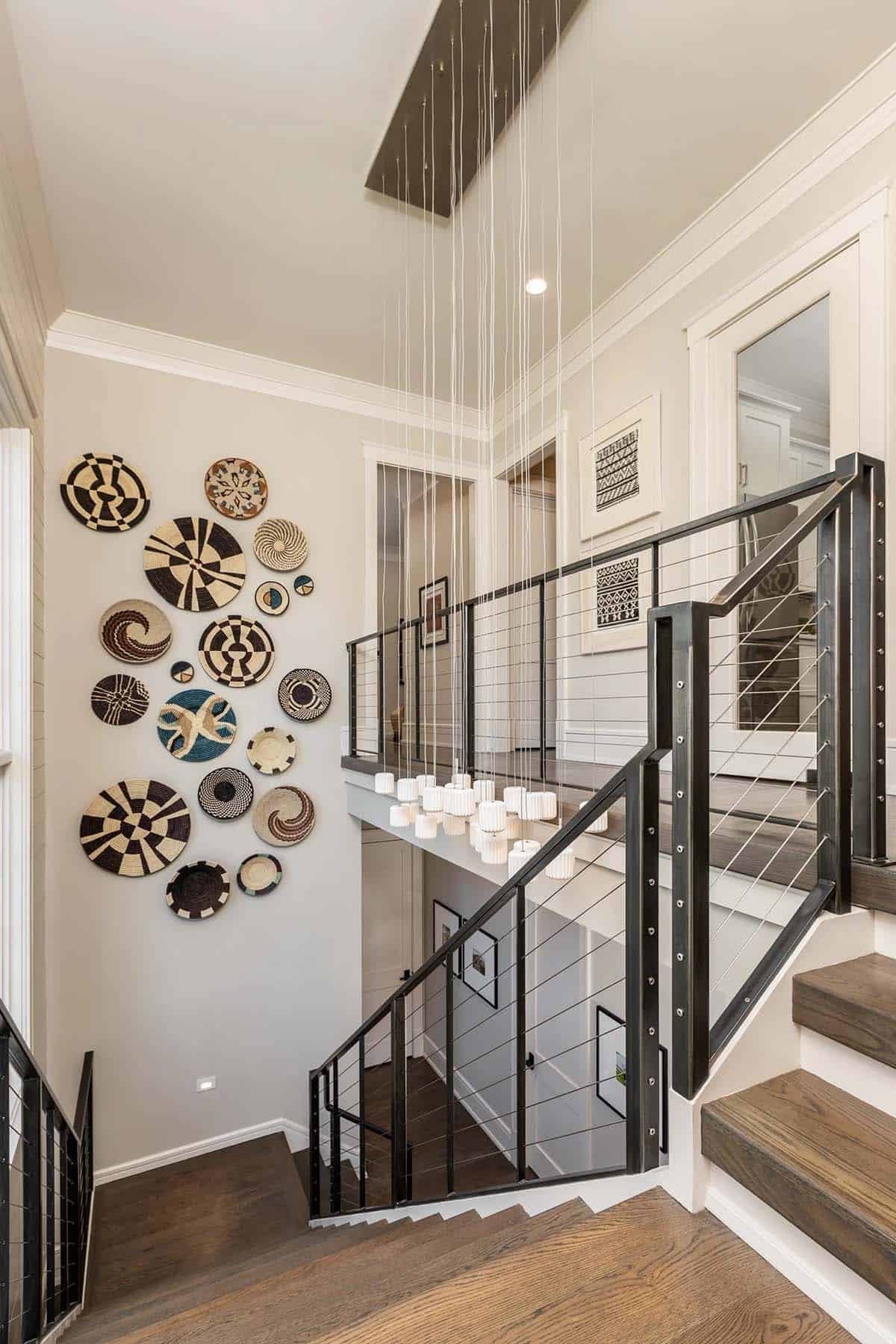 Open staircase landing with woven basket wall display and cascading pendant chandelier