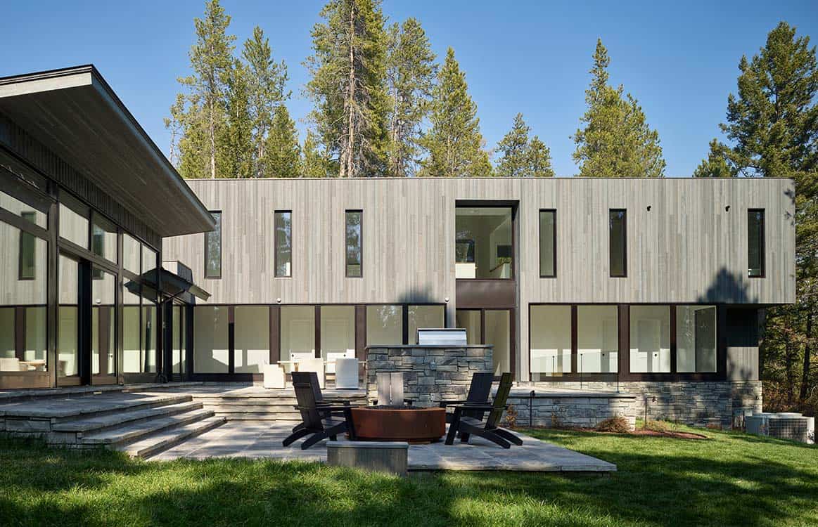 Modern wood-clad facade with vertical windows above a stone outdoor kitchen