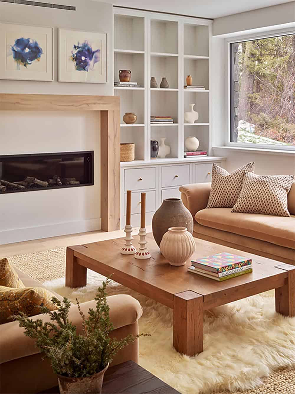 Cozy living room nook with linear fireplace, wood mantel, and white built-in shelving