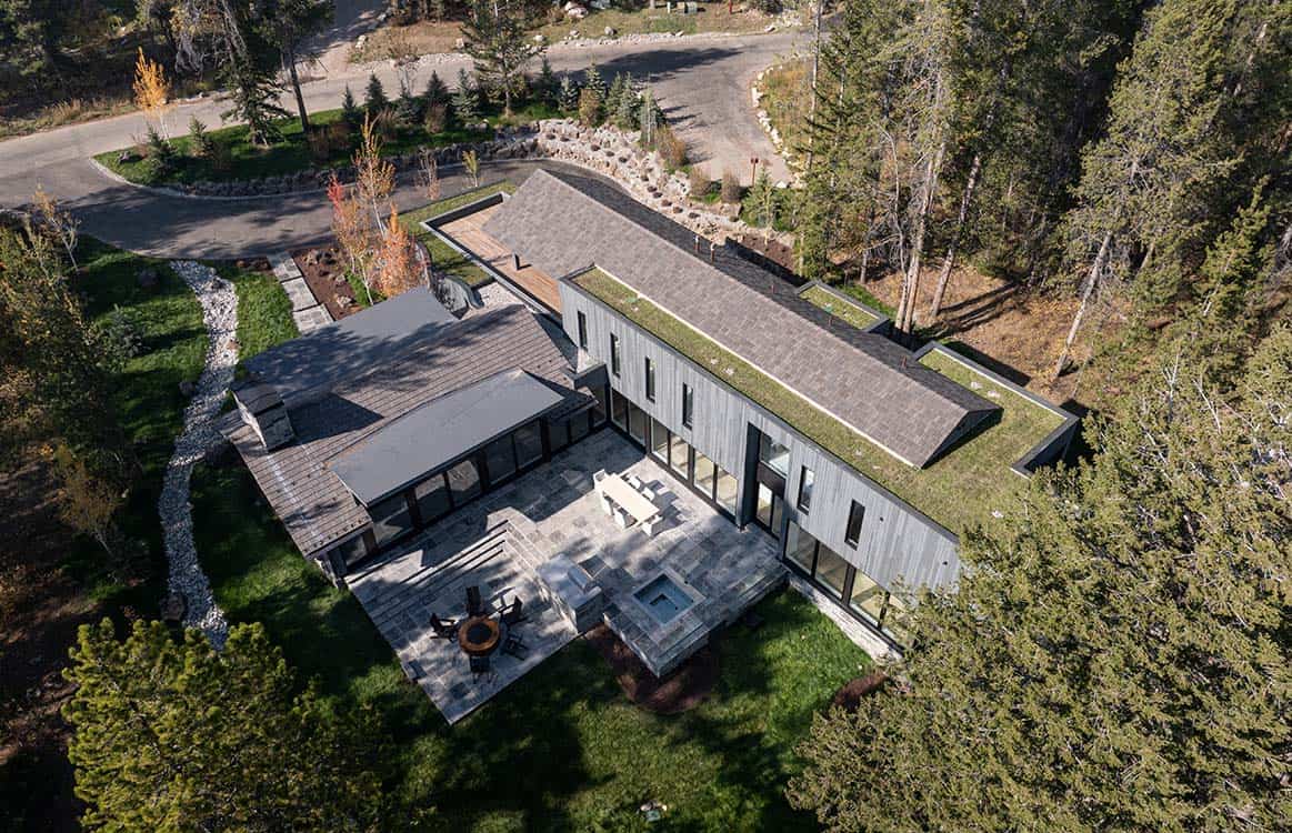 Overhead view of the home's angular rooflines, patio, and circular driveway