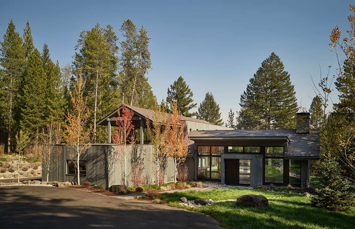Exterior view of the multi-gabled wood and stone home surrounded by autumn aspens