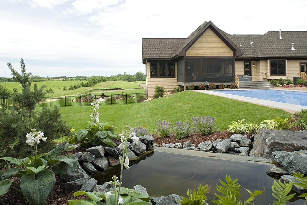 Backyard pool and landscaped lawn overlooking open pasture