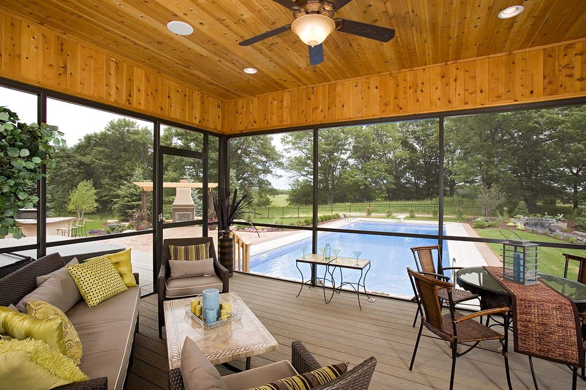 Screened porch with wicker furniture overlooking swimming pool