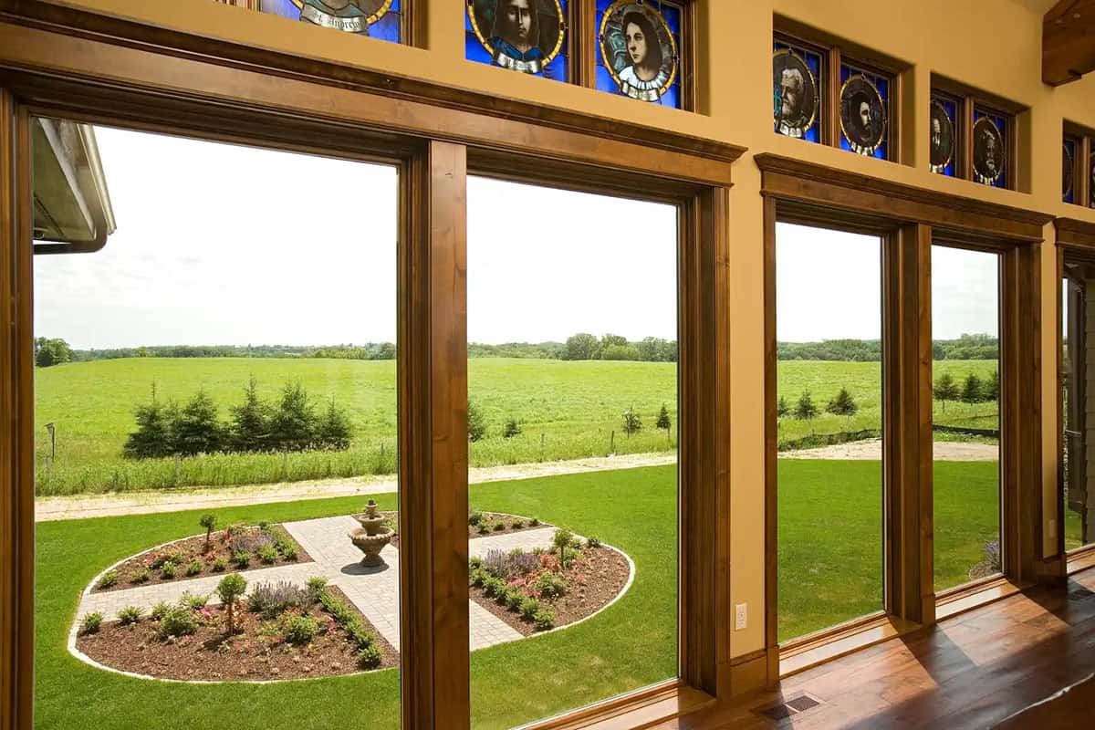 Interior view through wood-framed windows with stained glass transoms