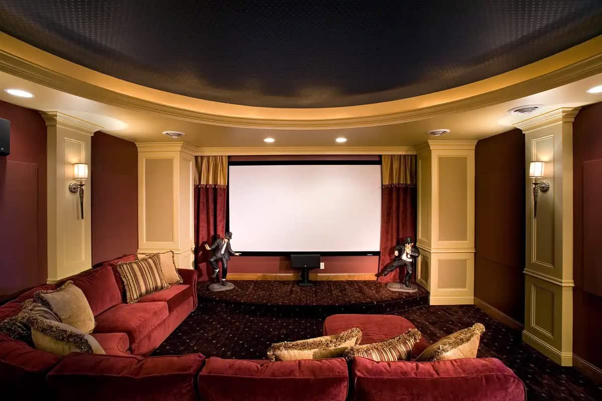 Curved home theater room with tiered seating and stage lighting