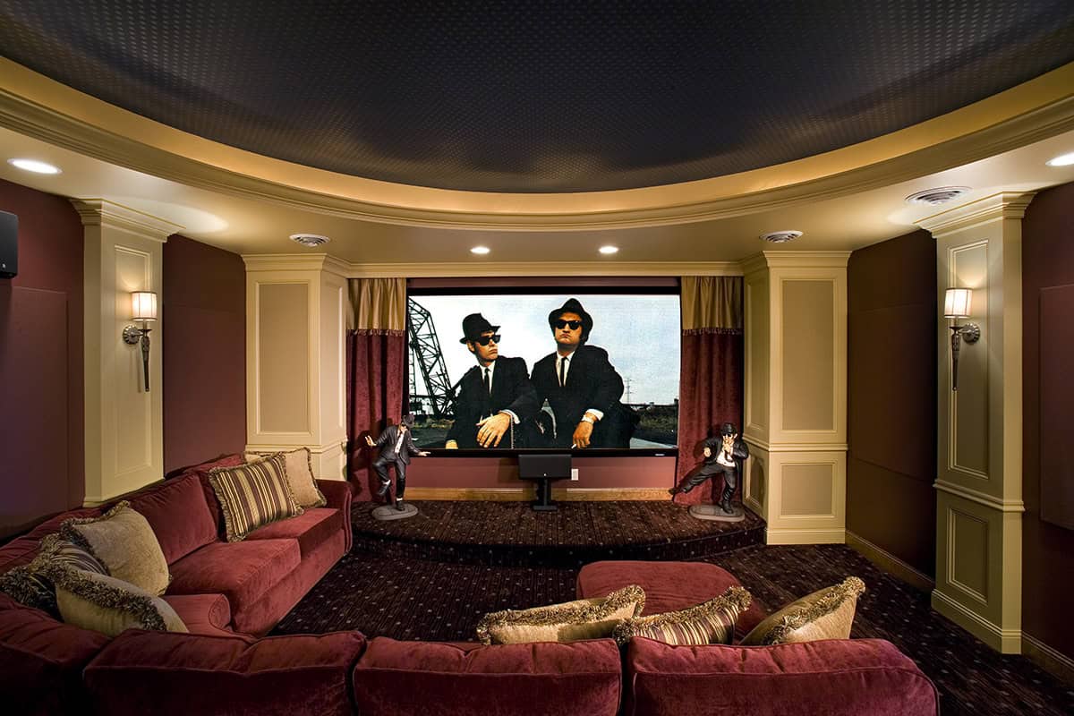 Home theater screen displaying movie with red velvet seating